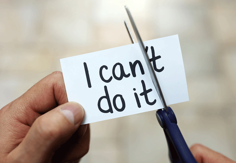 A close up of hands holding a card with the text `I can't do it` with scissors about to cut the card to make it read `I can do it`. Learn tips on finding self fulfillment in Toronto, CA by contacting an online therapist in Ontario, CA. Search ”therapy for finding fulfillment in Ontario” to learn more.