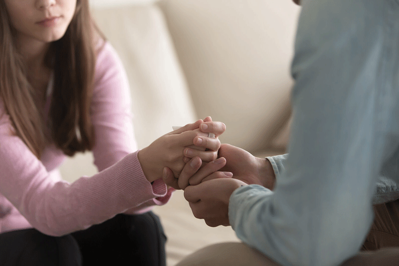 A close up of a couple holding hands while sitting across from one another. This could represent the communication necessary to create a fulfilling relationship in Ontario, CA. Learn more about how a therapist in Ontario can offer support for your relationship. Search for “lack of fulfillment in relationship ontario, ca” today.