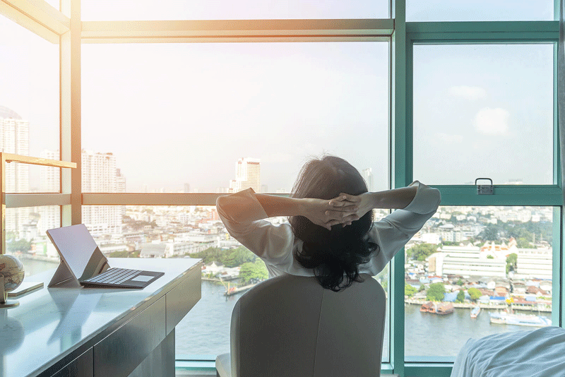 A woman sits in an office chair with her arms behind her head as she looks outside. This could represent the benefits of being more creative at work when working with a self fulfillment therapist in Ontario, CA. Learn more about self fulfillment in Toronto, CA by searching for “lack of fulfillment Toronto, CA” today. 